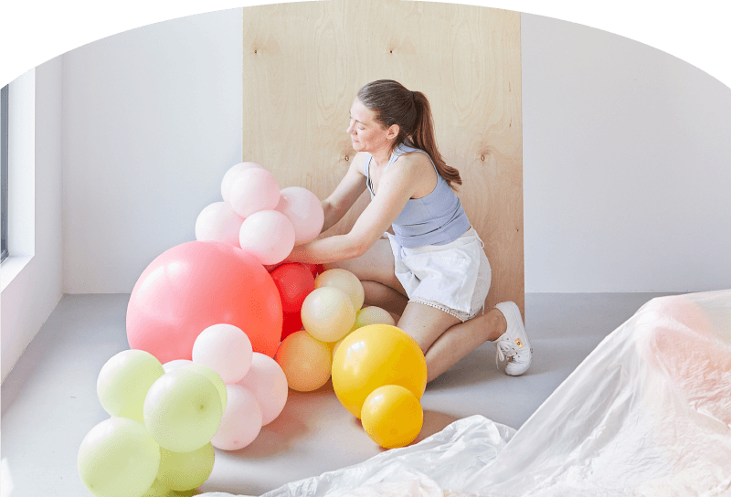 Float Balloons Hero Image pink background lady with balloons 
